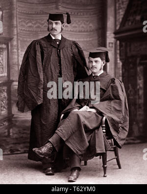 1890s 1900s TWO MEN COLLEGE UNIVERSITY GRADS GRADUATES POSING IN CAPS AND GOWNS - o2699 HAR001 HARS GRADUATES B&W GOALS MATCHING SAME SUCCESS MUSTACHE DREAMS HAPPINESS TURN OF THE 20TH CENTURY UNIVERSITIES AND CHOICE KNOWLEDGE DIRECTION GOWNS PRIDE OPPORTUNITY AUTHORITY FACIAL HAIR OCCUPATIONS POSING SIBLING HIGHER EDUCATION CAPS STYLISH COLLEGES EDUCATED LOOK-ALIKE DUPLICATE GRADS GROWTH LOOK ALIKE TOGETHERNESS YOUNG ADULT MAN BLACK AND WHITE CAUCASIAN ETHNICITY CLONE HAR001 OLD FASHIONED