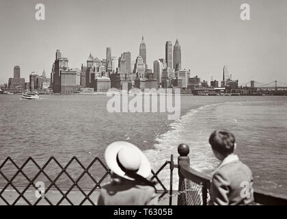 1950s YOUNG GIRL AND BOY RIDING ON STATEN ISLAND FERRY BOAT VIEWING SKYLINE OF LOWER MANHATTAN AND NEW YORK HARBOR NYC USA - r1649 HAR001 HARS HISTORY CELEBRATION FEMALES BROTHERS UNITED STATES COPY SPACE HALF-LENGTH LOWER SCENIC INSPIRATION UNITED STATES OF AMERICA MALES SIBLINGS CONFIDENCE SISTERS TRANSPORTATION B&W HARBOR FREEDOM WIDE ANGLE VISION DREAMS HEAD AND SHOULDERS ADVENTURE STRENGTH AND EXCITEMENT EXTERIOR LOOKING BACK OF ON NYC SIBLING CONCEPTUAL NEW YORK CITIES FERRY IMAGINATION STYLISH NEW YORK CITY JUVENILES TOGETHERNESS VIEWING BLACK AND WHITE CAUCASIAN ETHNICITY HAR001 Stock Photo
