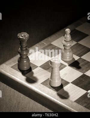 1960s CHECKMATE THREE CHESS PIECES SHOW OPPOSING BLACK KING HELD IN CHECK THREATENED WITH CAPTURE BY THE WHITE BISHOP AND ROOK - s15260 HAR001 HARS THREATENED ESCAPE ROOK SYMBOLIC CHECKMATE CONCEPTS OPPOSING SOLUTIONS BISHOP BLACK AND WHITE CAPTURE HAR001 OLD FASHIONED PERSONIFICATION REPRESENTATION Stock Photo