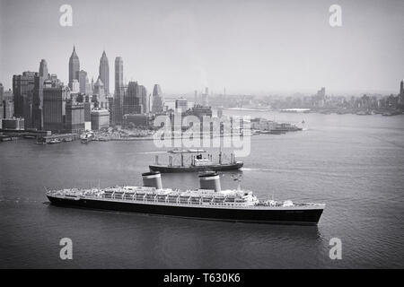 1950s PASSENGER LINER THE SS UNITED STATES HEADS OUT TO SEA FROM NEW YORK HARBOR NYC USA - s636 HAR001 HARS FASTEST MANHATTAN ISLAND BLUE RIBAND GROWTH OCEAN CROSSING OCEAN LINER TRANSATLANTIC AERIAL VIEW BLACK AND WHITE HAR001 HUDSON RIVER OLD FASHIONED VESSEL Stock Photo