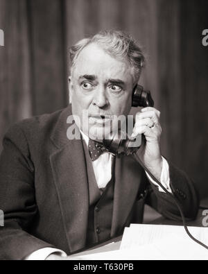 1930s BUSINESS MAN LISTENING ON TELEPHONE WITH ALARMED SHOCKED WORRIED FACIAL EXPRESSION - t3549 HAR001 HARS NOSTALGIA OLD FASHION 1 FACIAL ANGER COMMUNICATION SHOCK SHOCKED TROUBLE PROBLEM LIFESTYLE ELDER JOBS MANAGER COPY SPACE HALF-LENGTH PERSONS THOUGHTFUL MALES RISK SENIOR MAN EXECUTIVES SENIOR ADULT B&W SADNESS OCCUPATION SELLING OLDSTERS OLDSTER POLITICIAN STUNNED CONCERN OCCUPATIONS PHONES POLITICS ELDERS BOSSES TELEPHONES ATTORNEY FOCUSED INTENSE MANAGERS SALESMEN BLACK AND WHITE CAUCASIAN ETHNICITY HAR001 INTENT OLD FASHIONED Stock Photo