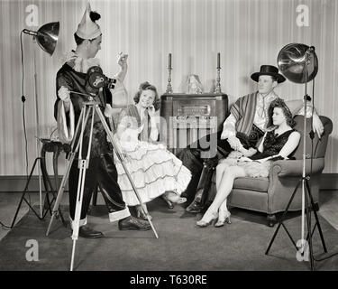 1940s GROUP OF YOUNG ADULTS COUPLES POSING WEARING PARTY COSTUMES MAN IN CLOWN COSTUME OPERATING HOME MOVIE CAMERA AND LIGHTS - u583 HAR001 HARS TEAMWORK SPANISH RELAXING COSTUMES LIFESTYLE CELEBRATION FEMALES HOME LIFE FRIENDSHIP FULL-LENGTH LADIES PERSONS MALES ENTERTAINMENT B&W SKILL ACTIVITY AMUSEMENT OPERATING HOBBY LEISURE LIVING ROOM INTEREST AND HOBBIES KNOWLEDGE RECREATION PASTIME PLEASURE IN OF POSING CONCEPTUAL STYLISH CREATIVITY RELAXATION TOGETHERNESS YOUNG ADULT MAN YOUNG ADULT WOMAN AMATEUR BLACK AND WHITE CAUCASIAN ETHNICITY ENJOYMENT HAR001 OLD FASHIONED Stock Photo