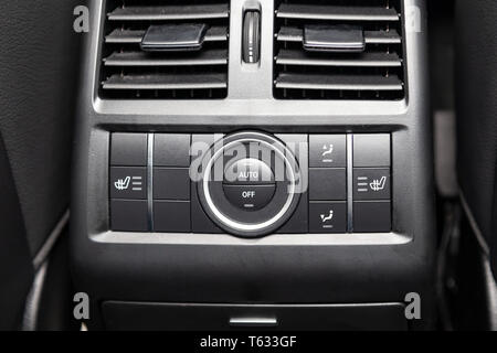 Rear central console on the panel inside the car close-up with climate control and seat heater buttons in gray and black. Auto service industry. Comfo Stock Photo