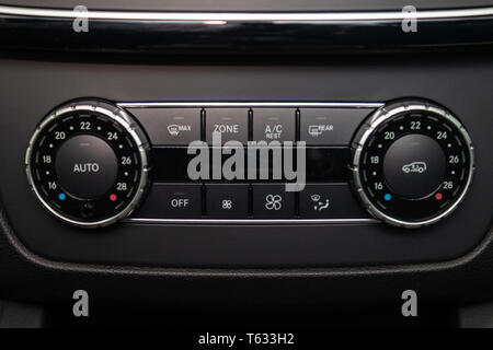 Rear central console on the panel inside the car close-up with climate control and seat heater buttons in gray and black. Auto service industry. Comfo Stock Photo