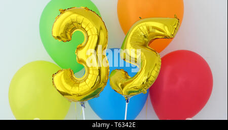 Gold foil number 35 celebration balloon on a color Stock Photo