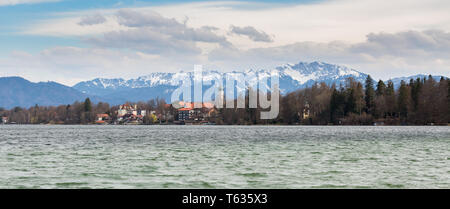 SEESHAUPT, BAVARIA / GERMANY - April 3, 2018: Panoramic view on Lake Starnberg with Seeshaupt (town w/ church) and alpine mountains in the background. Stock Photo