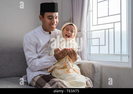 muslim father and kid praying together Stock Photo