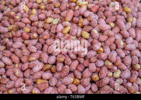 Peanuts snack salty. Red skin peanuts roasted and salted background, texture. Top view Stock Photo