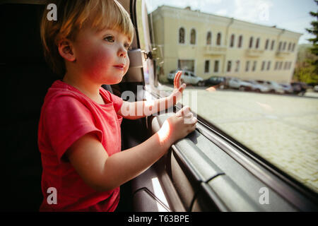 Little boy looking through car window