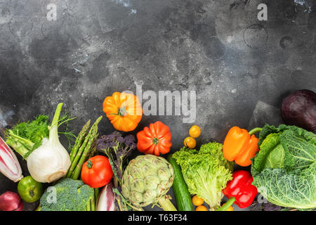 Fresh raw vegetables, cabbage carrots broccoli asparagus pepper fennel tomatoes salad artichocke, on dark black gray background, top view, copy space, Stock Photo