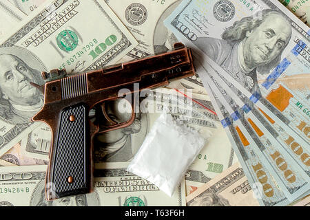 pistols and drugs against the background of dollars. Stock Photo