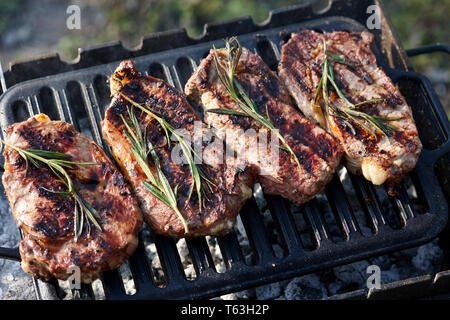 Juicy beef steaks cooking on grill outdoors Stock Photo