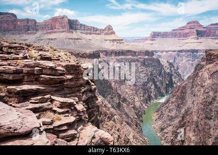 Couple of hikers enjoying a breathtaking view of the Colorado River from Plateau Point at Grand Canyon National Park, Arizona , USA Stock Photo