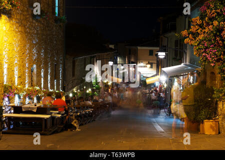 Castiglione della Pescaia, Italy - September 9, 2014: People and tourist walking and have dinner at night. In the territory of Castiglione Stock Photo