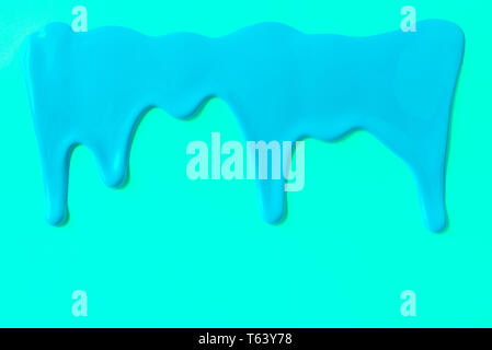 Blue paint leaking down trendy cyan background. Close up. Stock Photo