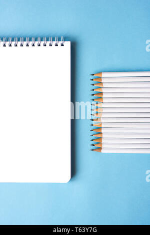 Pencils and a notebook on blue surface. Close up. Copy space for text Stock Photo