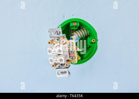 Round green light switch in process of installation inside gypsum plasterboard wall, close-up. Stock Photo