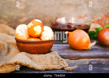 Easter eggs with pattern colored with onion peel on old wooden background. Stock Photo