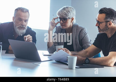 Business people at conference room looking at laptop. Corporate business team meeting in office. Stock Photo