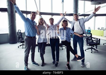 Portrait of creative business team standing together and laughing. Multiracial business people together at startup. Stock Photo