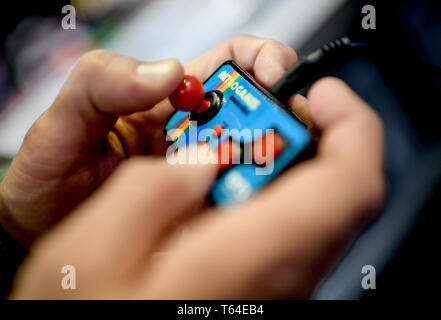 Berlin, Germany. 10th Apr, 2019. A young man plays a retro computer game in the exhibition 'Nineties Berlin' at the Alte Münze. (to dpa Skateboards, Bauchfrei, Nirvana - The 90s are back) Credit: Britta Pedersen/dpa-Zentralbild/dpa/Alamy Live News Stock Photo