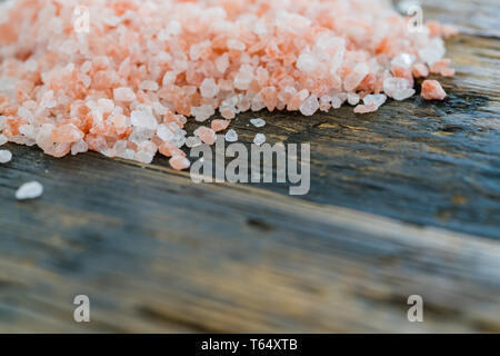 close up horizontal view of rose pink organic himalaya salt crystals on a rustic wooden table Stock Photo