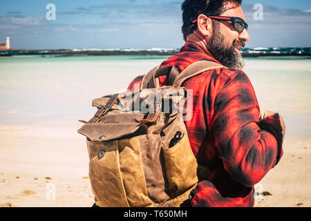 Travel and backpack wanderlust concept people with adult hipster man with beard and sunglasses enjoying the outdoor leisure activity with beach and be Stock Photo