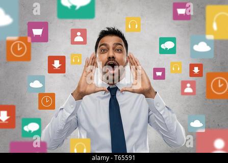 indian businessman shouting over app icons Stock Photo