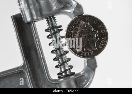 Iron vise tool with penny coin - Concept of stress, financial pressure Stock Photo