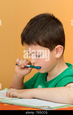 boy doing homework from school in workbook Stock Photo