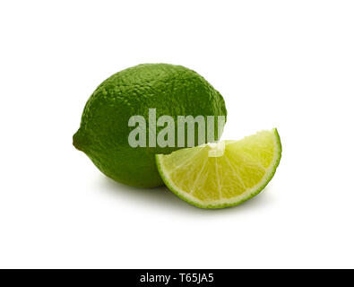 Close up one whole fresh green lime fruit and cut slice wedge, isolated on white background, low angle side view Stock Photo