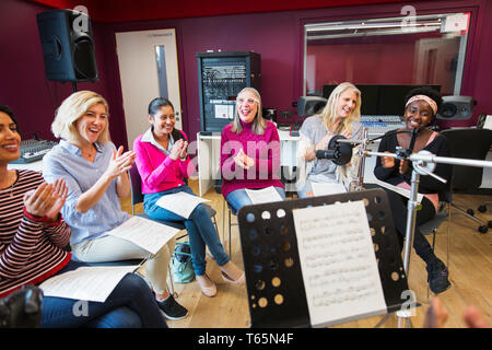 Womens choir with sheet music singing in music recording studio Stock Photo
