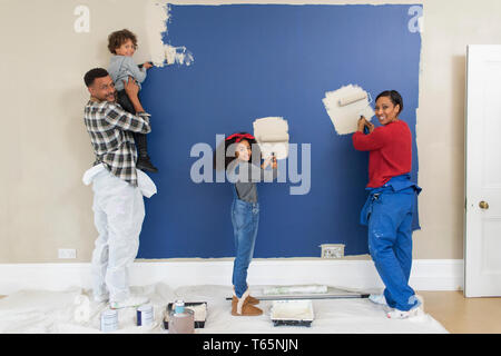 Portrait happy family painting wall Stock Photo