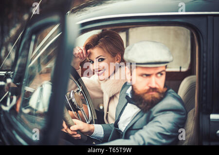 Escort of girl by security. escort concept with bearded driver and luxury girl in retro car. Stock Photo