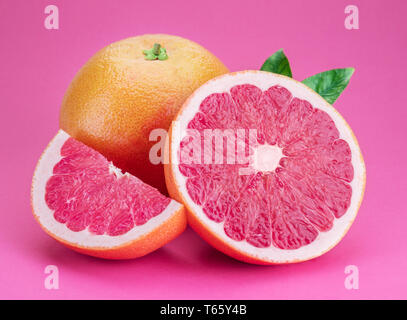 Grapefruit and grapefruit slices isolated on pink background. Stock Photo