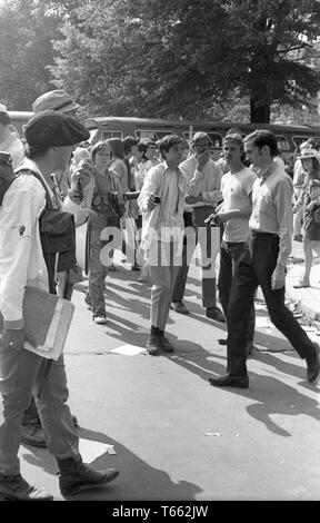 Eye-level shot of protestors, including a likely organizer at left who holds papers and a microphone, during the Kent State/Cambodia Incursion Protest, Washington, District of Columbia, May 9, 1970. () Stock Photo