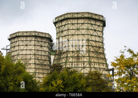 two old cooling towers with some trees in front Stock Photo