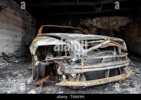 Close up photo of a burned out cars in garage after fire for grunge ...