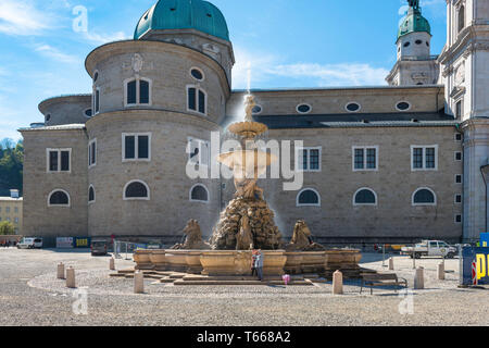 Salzburg Residenzplatz, view of a mother and daughter taking a photo beside the fountain sited in the Residenzplatz in Salzburg Old Town, Austria. Stock Photo