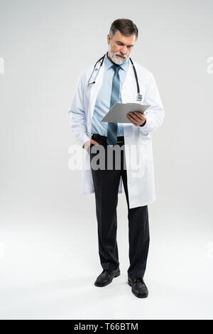 full body picture of a mature doctor holding a notepad, on white background  Stock Photo - Alamy