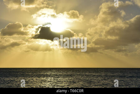 Beautiful sun shining down through the clouds over the ocean in Aruba. Stock Photo