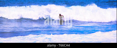 Hossegor, France - February circa , 2019. An unidentified surfer man catching riding on an ocean wave near the coast, on blue ocean, with good golden  Stock Photo