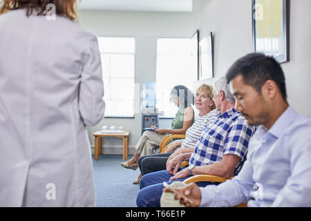 Patients waiting in clinic waiting room Stock Photo