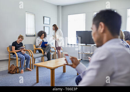 Doctor and patients in clinic waiting room Stock Photo