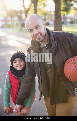 Portrait father and son with basketball in autumn park Stock Photo