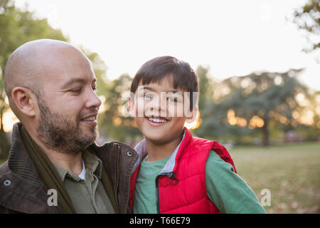Portrait happy father and son in autumn park Stock Photo