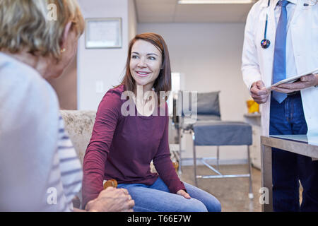 Doctor talking with patients in doctors office Stock Photo