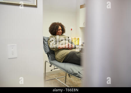 Female patient waiting in clinic examination room Stock Photo