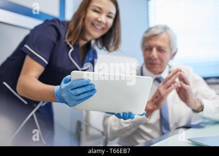 Doctor and nurse using digital tablet in clinic doctors office Stock Photo