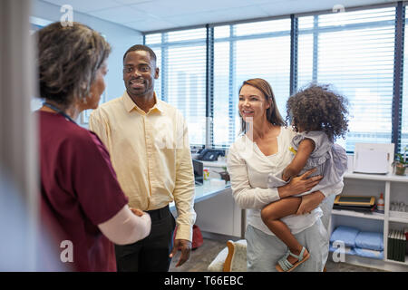 Doctor talking with family in clinic doctors office Stock Photo